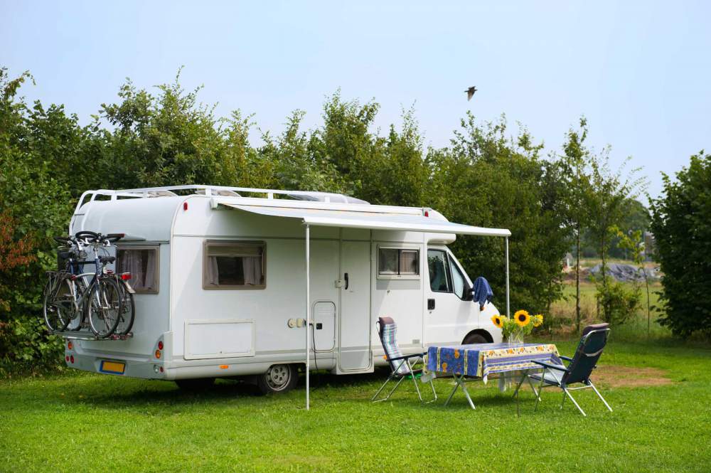 Mobile Caravan With Retractable Awning And Picnic Table At Campsite